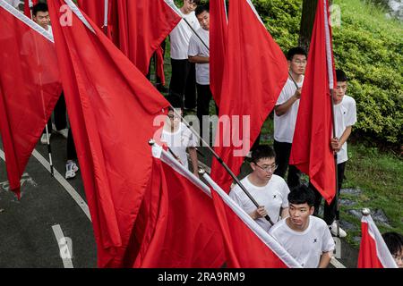 Wuhan, China. 01. Juli 2023. Junge Männer halten während des 102. Jahrestages der Gründung der CPC in Wuhan die Alarmflaggen. Vor dem Gründungstag des CPC zeigten offizielle Zahlen, dass die CPC-Mitgliedschaft von 2021 auf 98,04 Millionen Ende 2022 um fast 1,33 Millionen Dollar oder 1,4 Prozent gestiegen war. Kredit: SOPA Images Limited/Alamy Live News Stockfoto