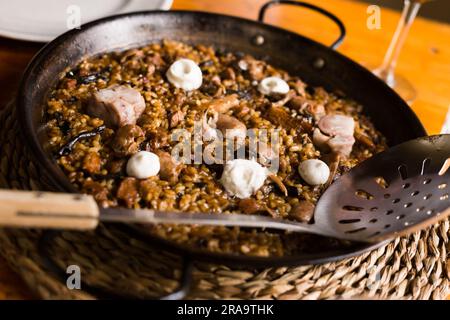 Köstlicher katalanischer Bergreis mit Pilzen und Schweinefüßen Stockfoto