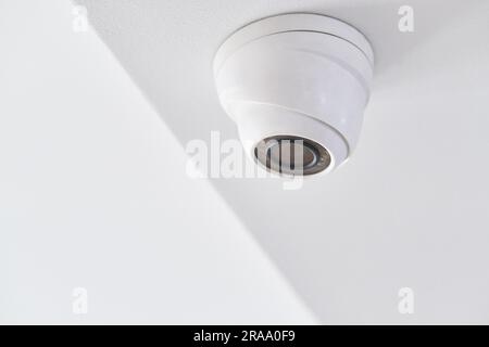 Videoüberwachung an der weißen Decke in einem modernen Gebäude Stockfoto