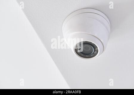 Videoüberwachung an der weißen Decke in einem modernen Gebäude Stockfoto
