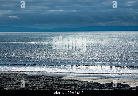 Blick aufs Meer von der Watch House Bay auf Barry Island im März. Barry Island ist an der Küste von Südwales und dieser Schuss wurde in die Sonne geschossen. Stockfoto