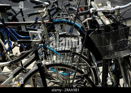 Bild mehrerer in der Stadt aufgestapelter Fahrräder, nachhaltiges und ökologisches Verkehrskonzept Stockfoto