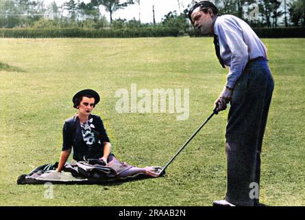 Frau Charles Sweeny, ehemals Miss Margaret Whigham und später Herzogin von Argyll (1912-1993), sah ihren Mann, eine amerikanische Golferin, die einen zehn-Yard-Putt versenkte - sie zog es vor, ein "grünes Ornament" zu sein, anstatt eine "Graswidow". Datum: 1938 Stockfoto