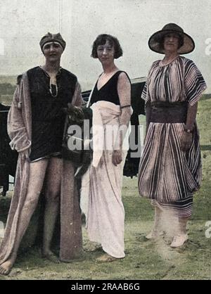 Lady Idina Gordon (Nee Sackville) im Bilderzentrum, in einem Badeanzug im schicken französischen Ferienort Deauville im Jahr 1921, mit Lady Drogheda auf der linken Seite und „einem Freund“. Fünfmal verheiratete Idina wurde berühmt als Teil des Happy Valley Sets, als sie 1924 mit ihrem dritten Ehemann, Josslyn Hay, Earl of Errol, nach Kenia zog. Mit ihren Serienehen und ihrem Ruf für verkommene Dekadenz inspirierte sie den Charakter von „The Bolter“ in Nancy Mitfords Romanen, das Streben nach Liebe und Liebe in einem kalten Klima, Evelyn Waughs Vile Bodies und die Figur Iris Storm in The Green hat Stockfoto