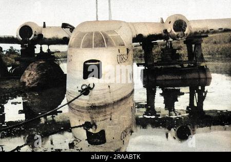 Das „Corsair“-Flugboot von Imperial Airways liegt nach einer Zwangslandung im März 1939 während eines Fluges von Durban nach Southampton halb unter Wasser im Fluss Dangu im belgischen Kongo (Zaire). Ein Flügel wird mithilfe von Pontons aus den aus Lastkraftwagen ausgebauten Benzintanks angehoben. Die Corsair wurde repariert, ein Damm errichtet, der einen See bilden sollte, und im Juni wurde ein Startversuch unternommen. Der Versuch schlug fehl und nachdem er auf einen Stein gestoßen war, waren weitere Reparaturen erforderlich. Schließlich wurde im Januar 1940, nachdem ein weiterer Damm errichtet wurde, die Corsair schließlich nach England zurückgebracht. Datum: Januar 40 Stockfoto