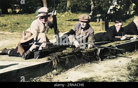 Mrs. Baliol Scott, die berühmte Gewehrschützin, brachte den Jungs bei, wie man auf der Byfleet Ladies' Rifle Range schießt, in der sie ein prominentes Mitglied war. Der Club gab allen Männern Anweisungen und kostenlose Munition, und das Bild hier zeigt einen Pfadfinder, der unter Mrs. Scotts wachsamem Auge auf ein Ziel zielt. Datum: 1914 Stockfoto