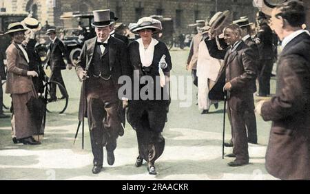 Winston Churchill, der erste Lord der Admiralität während der ersten beiden Jahre des Ersten Weltkriegs, fotografierte mit seiner Frau Clementine auf dem Weg in die Houses of Parliament, wobei Zuschauer ihre Hüte als Zeichen der Bewunderung hoben. Das war natürlich bevor er für seine Entscheidung über die verheerende Dardanelles-Kampagne im folgenden Jahr verantwortlich gemacht und angeprangert wurde. Datum: 1914 Stockfoto