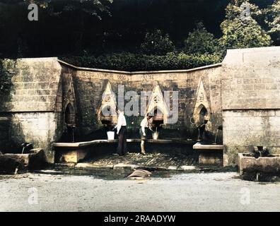 In der engen Hauptstraße des Cotswold-Dorfes Bisley, Gloucestershire, England, befinden sich die „Sieben Quellen“, die eine Quelle in sieben Brunnenabflüssen sind! Datum: 1930er Stockfoto