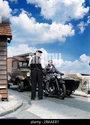 Der Maut wird erhoben: Ein Mann, der ein Motorrad und Beiwagen fährt, zahlt einen Maut im Barbican, Sandwich, Kent, England. Alle Fahrzeuge müssen bezahlen, um eine Brücke zu überqueren. Datum: Anfang 1940er Stockfoto