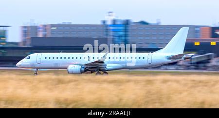Weißes neues Passagierflugzeug startet von der Landebahn ohne Logo mit Kopierbereich, Schwenkfoto Stockfoto