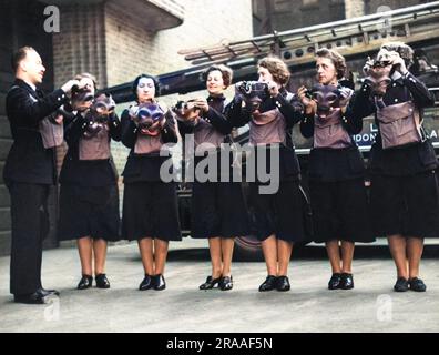 Frauen der Hilfsfeuerwehr, die im Zweiten Weltkrieg Gasmasken trainieren. Datum: 1940 Stockfoto