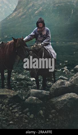 Eine Frau, die mit zwei Ponys an einem Regentag in Portree, Isle of Skye, Schottland reitet. Datum: 1926 Stockfoto