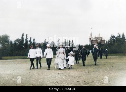 Zar Nicholas II. Von Russland spaziert durch die Landschaft von Krasnoe Selo in einem großen Gefolge, zu dem seine Frau Alexandra Feodorowna, eine seiner Töchter, andere Familienmitglieder und mehrere Beamte gehören. Datum: Ca. 1901 Stockfoto