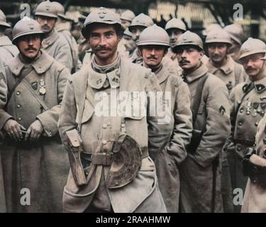 Eine Gruppe französischer Soldaten, die direkt aus den Schützengräben kamen, um britische Medaillen an der Westfront im Ersten Weltkrieg zu erhalten. Datum: Ca. 1916 Stockfoto