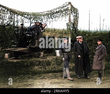 Arthur Balfour (zentrale Figur in flacher Kapuze) als Außenminister in David Lloyd Georges Koalitionsregierung aus Kriegszeiten, der während seines Besuchs an der Westfront (Ort unbekannt) im Herbst 1916 einen 9,2 cm großen britischen Howitzer beobachtete. Auf der rechten Seite steht Sir Philip Sassoon, Privatsekretär von Earl Haig während des Ersten Weltkriegs, ebenfalls Abgeordneter, Kunstsammler und Gastgeber der Gesellschaft. Datum: 1916 Stockfoto