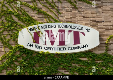 In Warren, Pennsylvania, USA, befindet sich ein Schild an der Seite eines Ziegelgebäudes, auf dem Efeu wächst Stockfoto