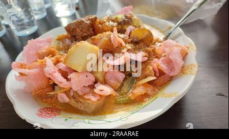 Lontong Sayur Padang oder Padangnese Reiskuchen scharfe Suppe auf einem Teller. In Jakarta, Indonesien. Stockfoto