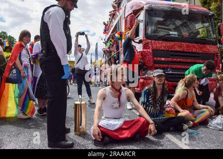 London, Großbritannien. 1. Juli 2023 Just Stop Oil-Aktivisten spritzten rosa Farbe und blockierten die Pride in London Parade, indem sie vor einem Coca-Cola-Truck saßen, der an der Parade teilnahm, um gegen Pride zu protestieren, der mit mit der Klimakrise in Verbindung stehenden Industrien arbeitete, und um gegen Coca-Cola zu protestieren, Gilt als der weltweit größte Verursacher von Plastik. Stockfoto