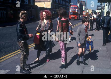 1970er Jahre Punks Teenager Mode Chelsea, London. The Kings Road, Chelsea, Samstagmorgen halten drei Punks an und plaudern, ein junger Schuljunge in seiner Schuluniform kommt vorbei. England 1979. UK HOMER SYKES Stockfoto