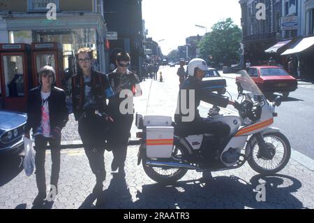 1970er Jahre Punk Street Fashion Chelsea, Street Fashion in der Kings Road, drei Punks und ein Polizist auf einem Motorrad. London, England 1979. UK HOMER SYKES Stockfoto