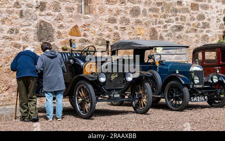 East Lothian, Schottland, Vereinigtes Königreich, 2. Juli 2023. Räder von gestern: Die jährliche Joggingtour der Scottish Association of Vehicles führt Besitzer von Oldtimern durch die Landschaft zu den malerischen Landschaften des Lennoxlove House. Abbildung: Enthusiasten bewundern die alten Autos, einschließlich eines alten 1920 Model T Ford und 1926 Morris Bullnose. Kredit: Sally Anderson/Alamy Live News Stockfoto