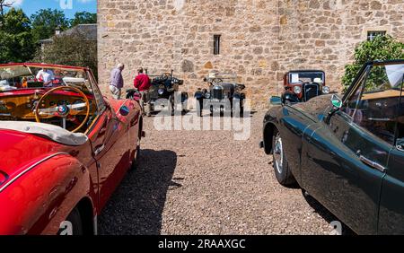 East Lothian, Schottland, Vereinigtes Königreich, 2. Juli 2023. Räder von gestern: Die jährliche Joggingtour der Scottish Association of Vehicles führt Besitzer von Oldtimern durch die Landschaft zu den malerischen Landschaften des Lennoxlove House. Abbildung: Enthusiasten bewundern die alten Autos, einschließlich der Oldtimer von Jowett. Kredit: Sally Anderson/Alamy Live News Stockfoto