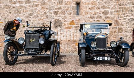 East Lothian, Schottland, Vereinigtes Königreich, 2. Juli 2023. Räder von gestern: Die jährliche Joggingtour der Scottish Association of Vehicles führt Besitzer von Oldtimern durch die Landschaft zu den malerischen Landschaften des Lennoxlove House. Abbildung: Ein Enthusiast bewundert die alten Autos, darunter einen 1920 alten Model T Ford und 1926 Morris Bullnose. Kredit: Sally Anderson/Alamy Live News Stockfoto