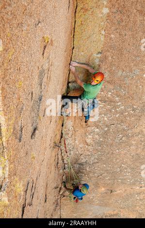 Männlicher Kletterer besteigt eine steile Felswand in den Dragoon Mountains, Cochise Stronghold, Arizona Stockfoto