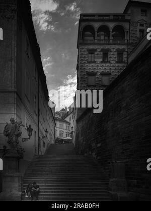 Schwarzweißansicht der historischen Steintreppen in der Prager Altstadt, Tschechische Republik, mit einem schmalen Durchgang und alter Architektur Stockfoto