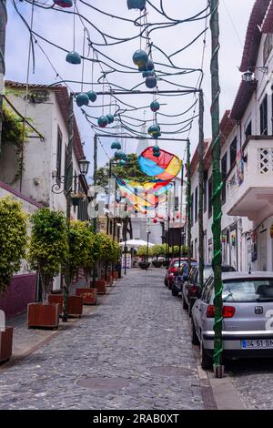 Kunstwerke aus Dutzenden von mehrfarbigen Regenschirmen, die über einer Straße in Camara de Lobos, Madeira, hängen. Stockfoto