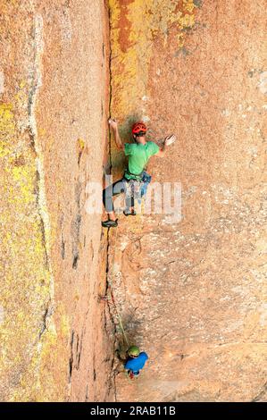 Männlicher Kletterer besteigt eine steile Felswand in den Dragoon Mountains, Cochise Stronghold, Arizona Stockfoto