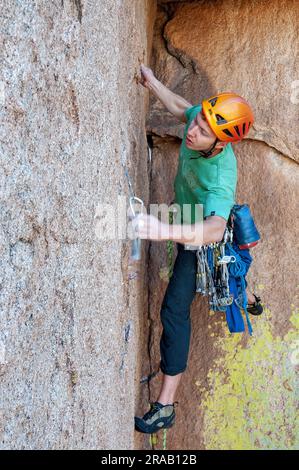 Männlicher Kletterer besteigt eine steile Felswand in den Dragoon Mountains, Cochise Stronghold, Arizona Stockfoto