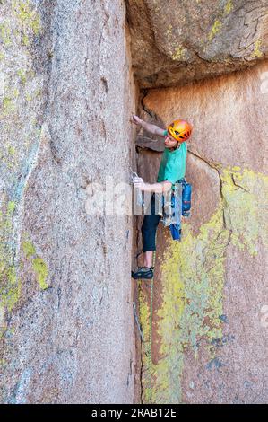 Männlicher Kletterer besteigt eine steile Felswand in den Dragoon Mountains, Cochise Stronghold, Arizona Stockfoto