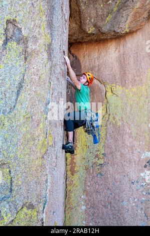 Männlicher Kletterer besteigt eine steile Felswand in den Dragoon Mountains, Cochise Stronghold, Arizona Stockfoto