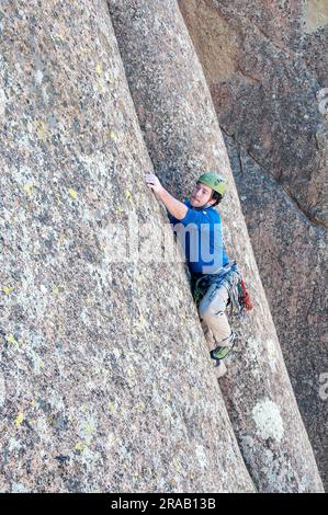 Männlicher Kletterer besteigt eine steile Felswand in den Dragoon Mountains, Cochise Stronghold, Arizona Stockfoto