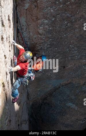 Männlicher Kletterer besteigt eine steile Felswand in den Dragoon Mountains, Cochise Stronghold, Arizona Stockfoto