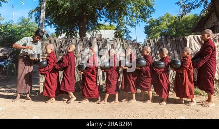 Bagan, Myanmar - 9. Dezember 2014: Buddhistische Neulinge Mönche, die in Bagan Almosen suchen. Stockfoto