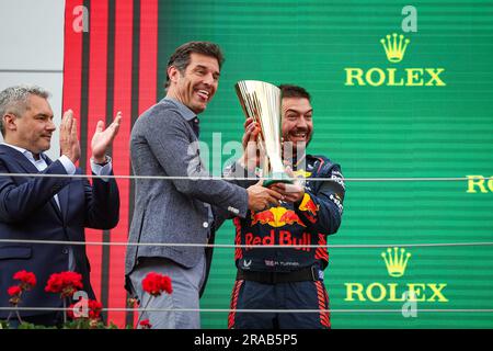 WEBBER Mark (aus), ehemaliger F1-Fahrer und TV-Moderator, auf dem Podium, der dem Red Bull Racing Mechanic während der Formel 1 Rolex Grosser Preis von Osterreich 2023, dem österreichischen Grand Prix 2023, der 9. Runde der Formel-1-Weltmeisterschaft 2023 von Juni 30 bis Juli 2 die Trophäe überreichte, 2023 auf dem Red Bull Ring in Spielberg, Österreich Stockfoto