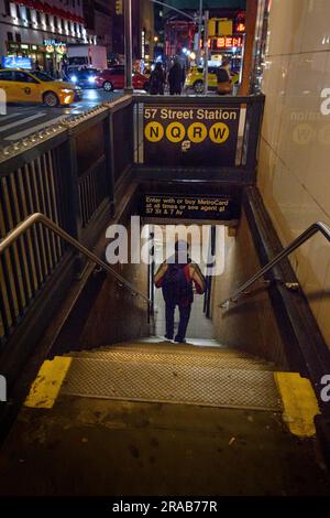 Nachts geht ein Mann die Treppe zur U-Bahn-Station in der 57. Straße hinunter. Stockfoto