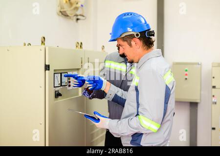 Professionelle Ingenieure, die Solarmodule auf Solarzellenfarmen warten Stockfoto