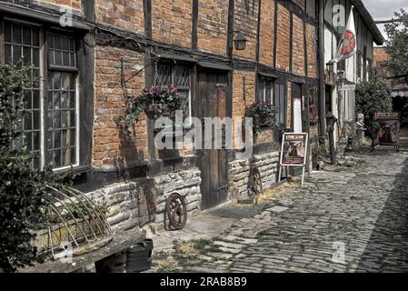 Eingang zum TUDOR World Museum mit kopfsteingepflasterter Gasse aus dem 16. Jahrhundert und Fachwerkhäusern Shrieves House Sheep Street Stratford upon Avon. UK Stockfoto