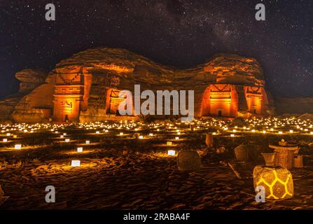 Sternenlicht über den antiken nabatäischen Gräbern der beleuchteten Stadt Hegra, Nachtpanorama, Al Ula, Saudi-Arabien Stockfoto