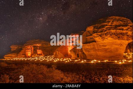 Sternenlicht über den antiken nabatäischen Gräbern der beleuchteten Stadt Hegra, Nachtpanorama, Al Ula, Saudi-Arabien Stockfoto