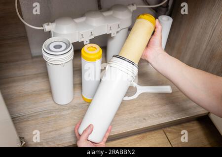 Der Installateur installiert oder wechselt den Wasserfilter. Ersatz-Aqua-Filter Stockfoto