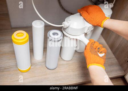 Der Installateur installiert oder wechselt den Wasserfilter. Ersatz-Aqua-Filter Stockfoto