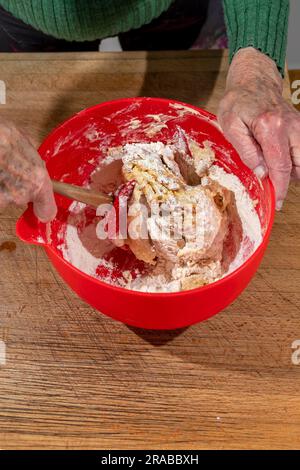 Eine Frau kocht Teig mit einem Teigschaber, um irisches Soda-Brot zuzubereiten Stockfoto