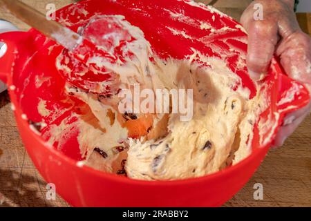 Eine Frau kocht Teig mit einem Teigschaber, um irisches Soda-Brot zuzubereiten Stockfoto
