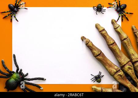 Halloween-Modell, leeres weißes Blatt Papier mit Spinnen und Monsterhand Stockfoto