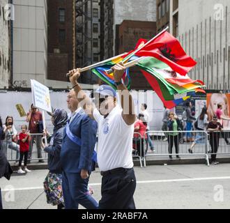 Bürgermeister Eric Adams marschiert in der Immigranten-Parade mit einer Vielzahl internationaler Flaggen, die verschiedene Einwanderergemeinschaften repräsentieren, die Teil des Gefüges sind, aus dem New York City besteht. Stockfoto