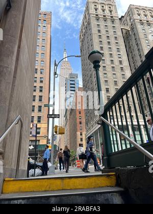 Verlassen Sie die U-Bahn-Station 33. Street #6 und fahren Sie in die vertikale Stadt, wobei das Empire State Building in Manhattan geradeaus Richtung Westen verläuft. Stockfoto